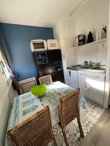 - une cuisine avec une table et un bol vert dans l'établissement Appart à la plage, à Saint-Jean-de-Monts