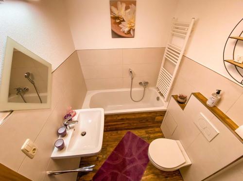 ein Badezimmer mit einem Waschbecken, einer Badewanne und einem WC in der Unterkunft Ferienhaus Alpenglück in Gaicht