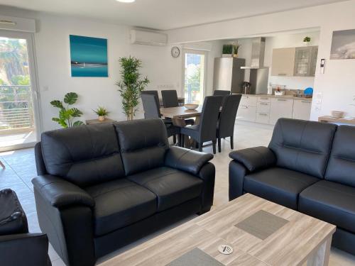 un salon avec deux canapés et une table dans l'établissement Appartement 3 chambres LE BAIA, à Sainte-Maxime