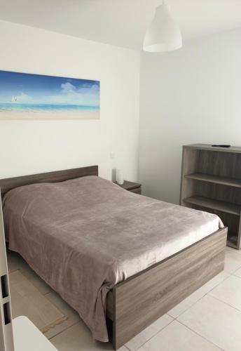 une chambre avec un lit et un tableau au mur dans l'établissement Appartement 3 chambres LE BAIA, à Sainte-Maxime