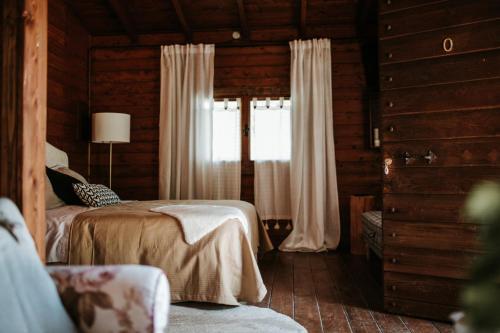 1 dormitorio con 1 cama y una ventana con cortinas en L'Anfora Country Club en Basciano