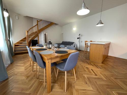 jadalnia z drewnianym stołem i niebieskimi krzesłami w obiekcie White Swan Boutique Apartments w Pradze