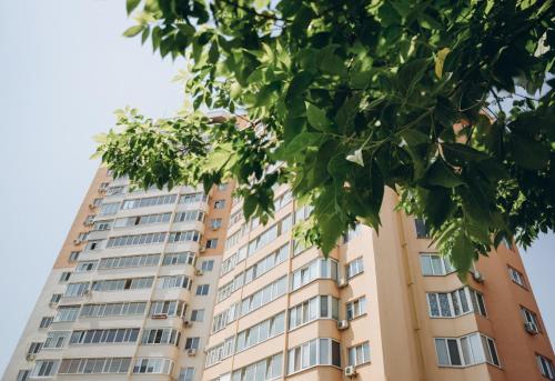 a tall building with a tree in front of it at Apart Lux Loft Panorama in Sumy