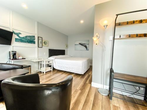 Schlafzimmer mit einem Bett, einem Schreibtisch und einem Stuhl in der Unterkunft Hôtel Motel Le Beluga in Tadoussac