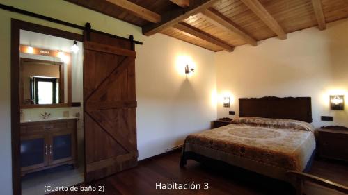 1 dormitorio con 1 cama y puerta de madera grande en Casa do Médico, en Presqueira