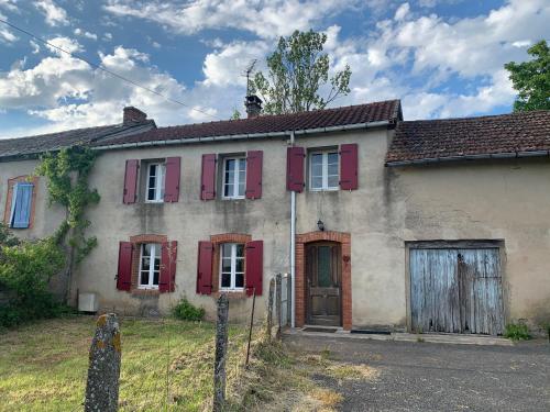 Une vieille maison avec des volets rouges dans l'établissement La Maison de Gaston, à Saint-Cirgue