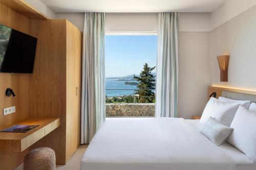 a hotel room with a bed and a large window at Greenstone Villas Corfu - Luxury Sea View Villas in Pyrgi