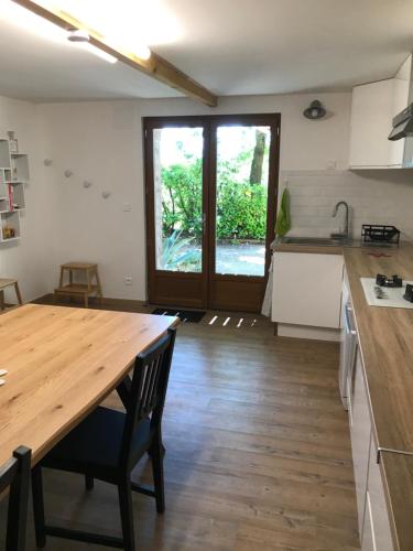 a kitchen with a wooden table and a wooden floor at gîte de Fontjalabert en campagne tout confort in Lisle-sur-Tarn