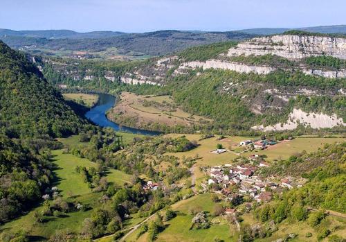 een luchtzicht op een vallei met een rivier bij La Belle Rivière in Bolozon