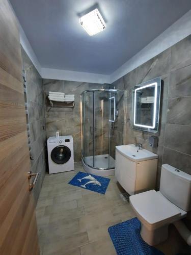 a bathroom with a shower and a toilet and a sink at Apartament Rebeca Lux by Alezzi Beach Resort in Mamaia Sat/Năvodari