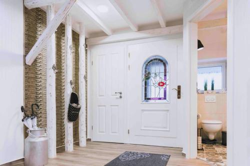 a hallway with a white door with a window at Einzigartiges Ambiente im ScheunenLoft in Küllstedt