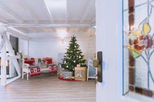 a christmas tree in the middle of a living room at Einzigartiges Ambiente im ScheunenLoft in Küllstedt