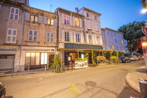 un vieux bâtiment avec un magasin dans une rue de la ville dans l'établissement L'EXCELLENCE AVIGNON - Suite LUXE SAUNA, HAMMAM & JACCUZZI, à Avignon