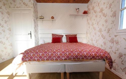 a bedroom with a bed with a red comforter at Le Galaveyson in Le Grand Serre