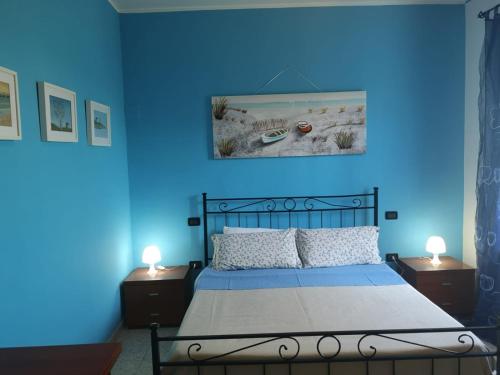 a blue bedroom with a bed with two nightstands and two lamps at B&B Stella dell'Adriatico in Ortona