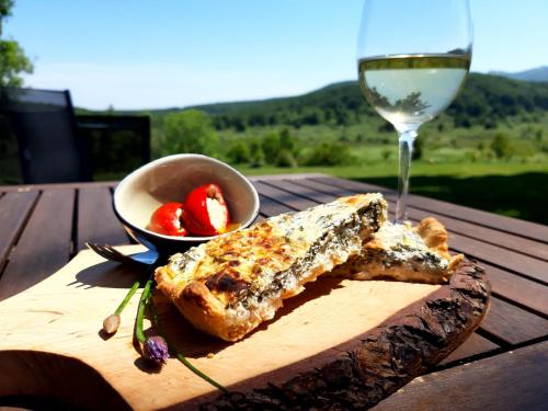 a wooden table with a glass of wine and some food at Tesla's Gastro House Plitvice in Plitvička Jezera
