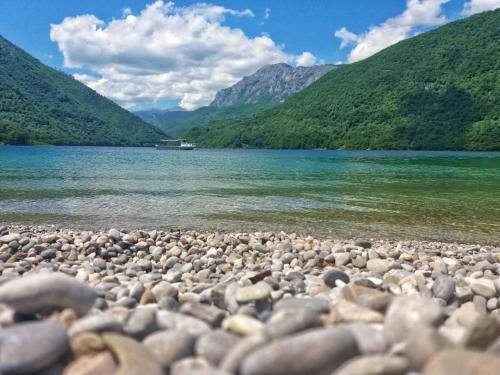 a large group of rocks on the shore of a lake at Guesthouse Madzarevic in Pluzine