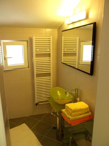 a bathroom with a green sink and a mirror at House Merlin in Baška Voda