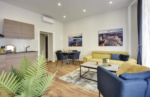 a living room with a yellow couch and a table at D&A Central Luxury Apartments with FREE Parking in Pula