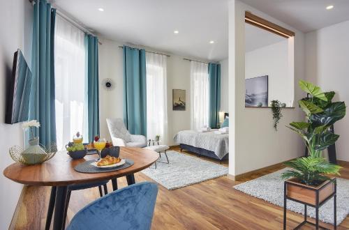 a living room with a table and blue curtains at D&A Central Luxury Apartments with FREE Parking in Pula