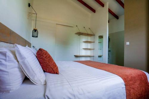 a bedroom with a large white bed with red pillows at Kâz corail in Sainte-Anne