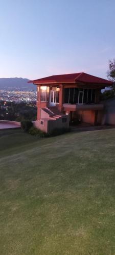 a house with a lawn in front of it at Hotel Monte Campana Escazu in San José