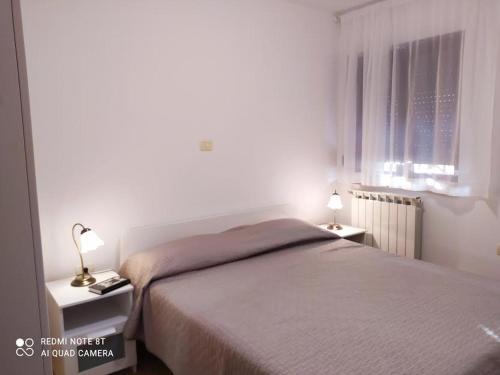 ein Schlafzimmer mit einem Bett und zwei Tischen mit Lampen in der Unterkunft Apartman Snježana in Fažana