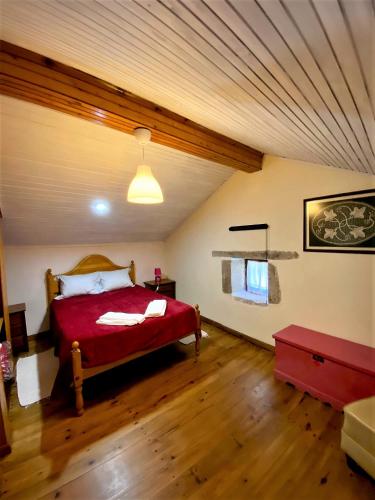 a bedroom with a red bed in a attic at Casa da Azenha Branca in Castelo do Neiva
