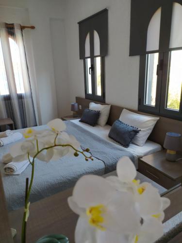 two beds in a room with white flowers on the floor at Lena Apartments in Elounda