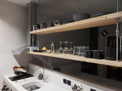 a kitchen with a sink and shelves with pots and pans at Ermoupolis hidden gems in Ermoupoli