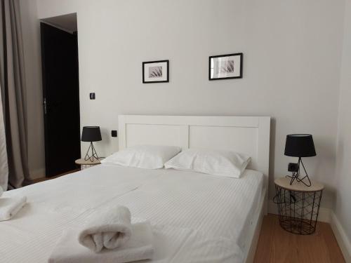 a bedroom with a white bed with towels on it at Ermoupolis hidden gems in Ermoupoli