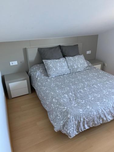 1 dormitorio con 1 cama y 2 mesitas de noche en Apartamento Praia de Quenxe, en Corcubión