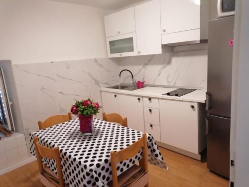 a kitchen with a table with a vase of flowers on it at Downtown Dream Makarska in Makarska