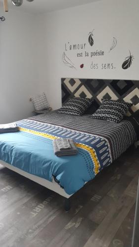 - un lit dans une chambre avec un panneau mural dans l'établissement Chambre d'hôte la coccinelle, à Meschers-sur-Gironde