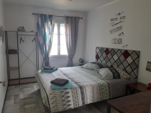 een slaapkamer met een bed en een raam bij Chambre d'hôte la coccinelle in Meschers-sur-Gironde