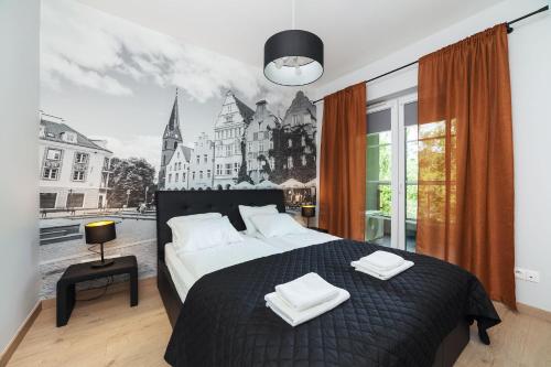 a bedroom with a large bed with a black and white picture at Villa Jana in Olsztyn