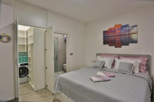 ein Schlafzimmer mit einem Bett mit rosa Handtüchern darauf in der Unterkunft Apartments Maris in Kaštela