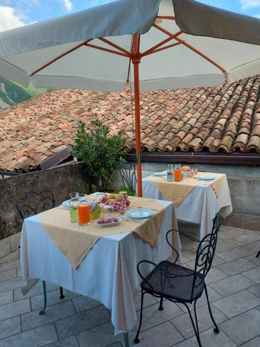 two tables with food and drinks sitting on a patio at La Piazzetta di Canale B&B in Tenno