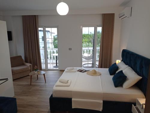 a bedroom with a large bed with blue pillows at Vasiliu Boutique Hotel Ksamil in Ksamil