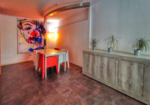 un comedor con una mesa y una pintura en la pared en Ciacco Hotel, en Gioia del Colle