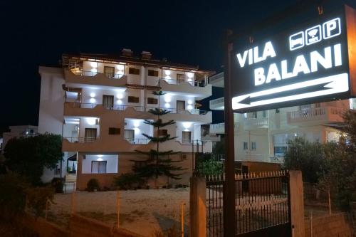 un panneau de rue devant un bâtiment la nuit dans l'établissement Vila Balani, à Ksamil