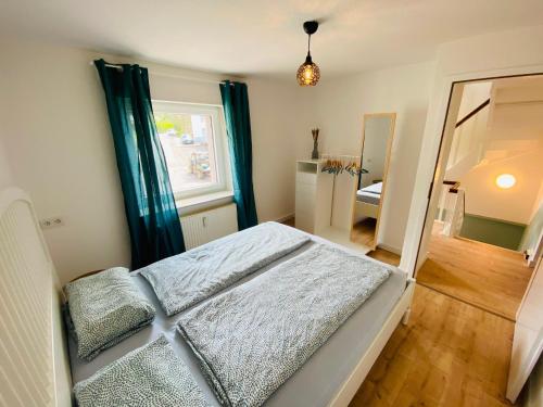 a bedroom with a large bed and a mirror at Auszeit-Eifel „Eifelhorst“ in Willwerscheid