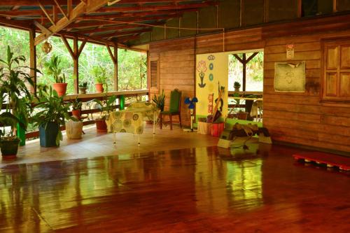 a large room with wooden walls and floors and plants at Hotel La Cascada in Puntarenas