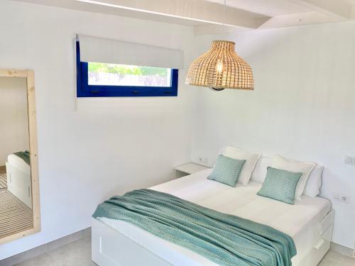 ein weißes Schlafzimmer mit einem Bett und einem Spiegel in der Unterkunft Villa Nature con Piscina Privada · Wifi ·AC · BBQ in Blanes