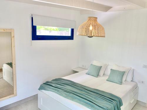 a white bedroom with a bed and a mirror at Villa Nature con Piscina Privada · Wifi ·AC · BBQ in Blanes