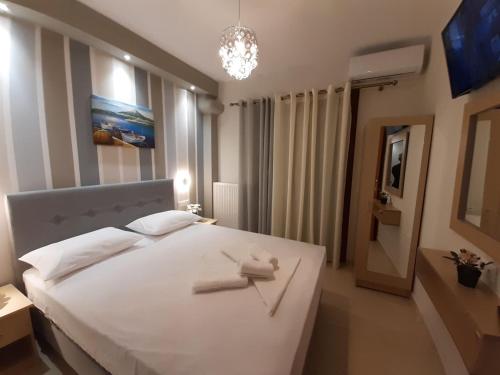 a bedroom with a large white bed with two towels on it at Modern Apartment Kallithea 1 in Kallithea Halkidikis