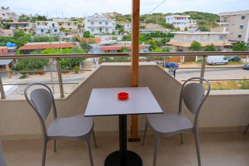 a table and chairs on a balcony with a view of a city at Vila Balani in Ksamil
