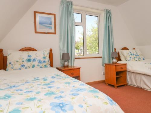 a bedroom with two beds and a window at Dartmoor 2 in Callington