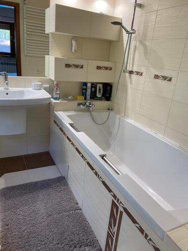 a bathroom with a shower and a tub and a sink at Dom nad jeziorem in Słupia
