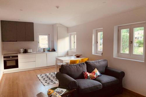 a living room with a couch and a kitchen at Casa do Rio. Sossego à beira rio. in Rio de Onor